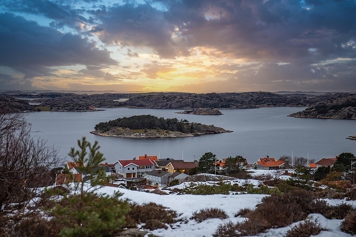 View over a rocky coastal landscape in winter. Snow, ice and withered heather. Landscape photograph in the town of Fjällbacka, west coast of Sweden, by Jan Wehnert