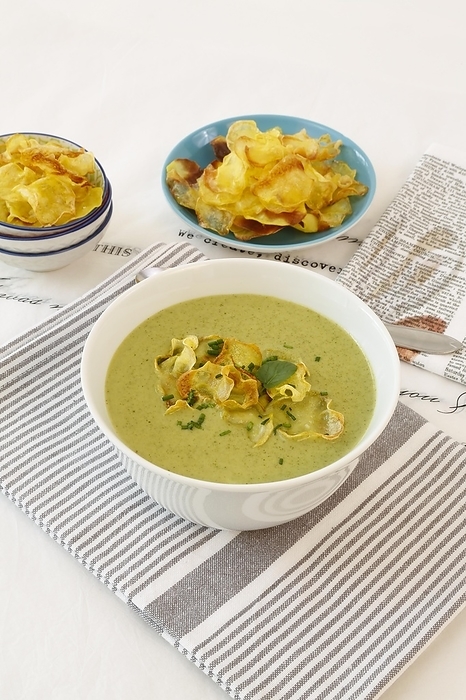 Swabian cuisine, cress soup with crisps, cress, plate with green cream soup, soup bowl, garnished with herbs, hearty soup, bowl with crisps, tea towel, writing, letters, vegetarian, healthy, salty, cooking, typical Swabian reinterpreted, traditional cuisine, food photography, studio, tablecloth, Germany, Europe, by Katharina Hild