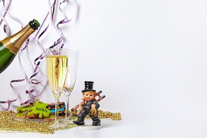 Two champagne glasses, pouring champagne, lucky charm for New Year, white background, copy space, by Lucas Seebacher