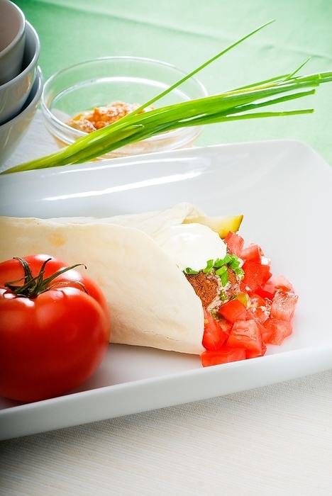 Fresh traditional falafel wrap on pita bread with fresh chopped tomatoes, by keko64