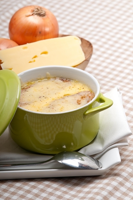 Onion soup on clay pot with melted cheese and bread on top, by keko64