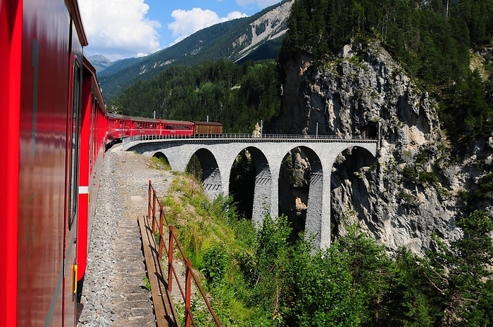 One way to the WEF: The Glacier Express Unesco World Heritage train trip through the swiss alps at the famous Landwasser Viaduct, by Gerd Michael Müller