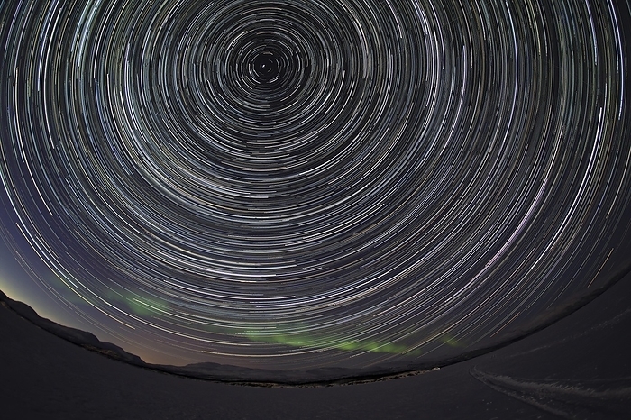 Star trails with faint northern lights over Torneträsk lake, Abisko, Sweden, Europe, by Heckmann Dirk