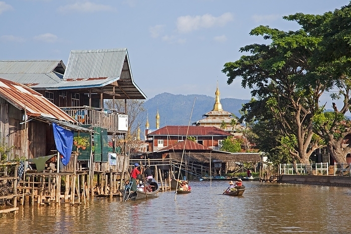 Intha villagers in proas at lakeside village with traditional bamboo houses on stilts and Buddhist temple, Inle Lake, Nyaungshwe, Shan State, Myanmar, Burma, Asia, by alimdi / Arterra / Marica van der Meer