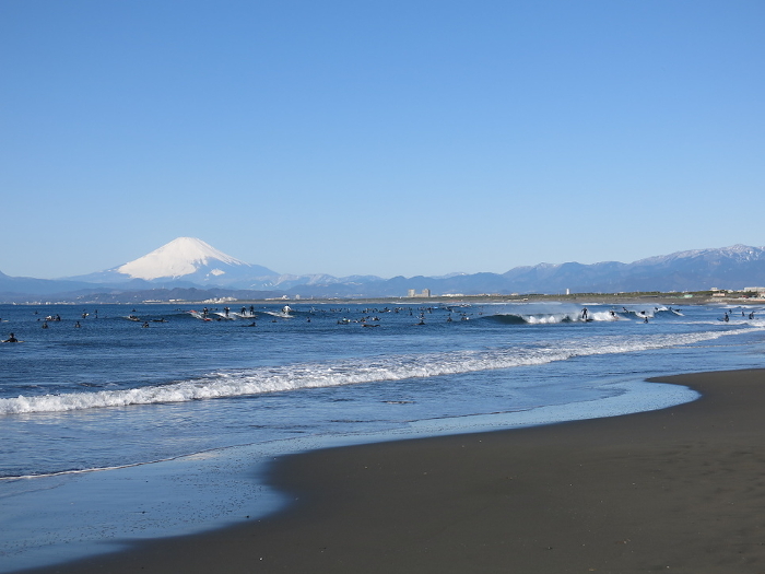 West beach of Katase coast in winter crowded with surfers (Mt. Fuji in the back left)