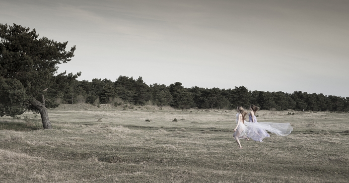Germany, Bavaria, Froettmaning Heath, young women wearing a tulle dress and running