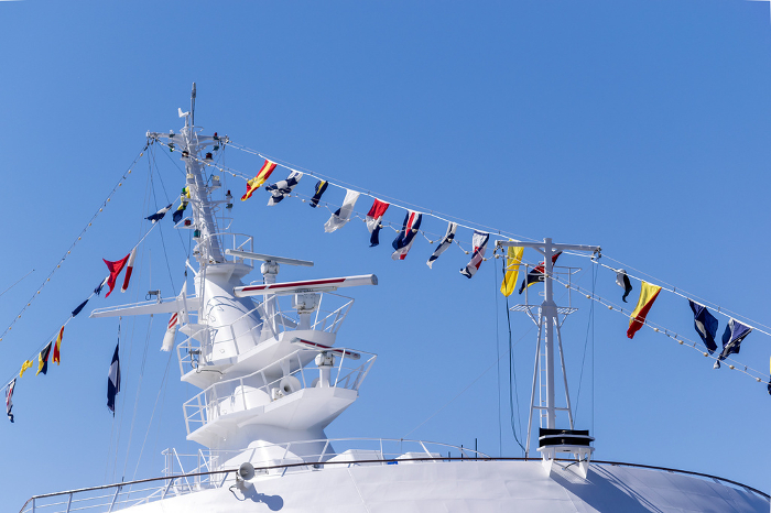 Mast and signal flags of a luxury liner against the blue sky