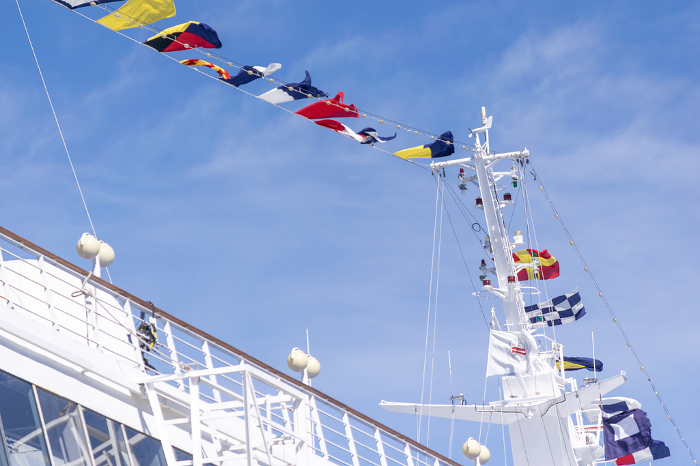 Mast and signal flags of a luxury liner against the blue sky