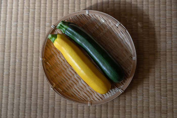 Two zucchini on colander Green and yellow zucchini on tatami mats in a Japanese-style room