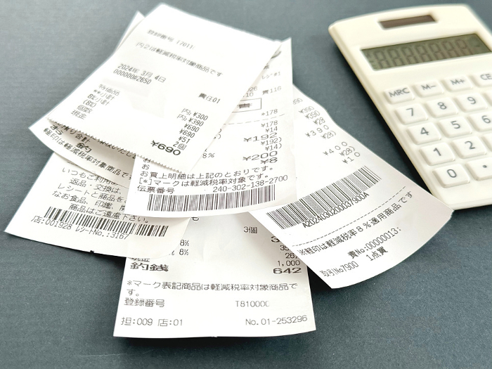 Lots of receipts and calculator_close-up black background