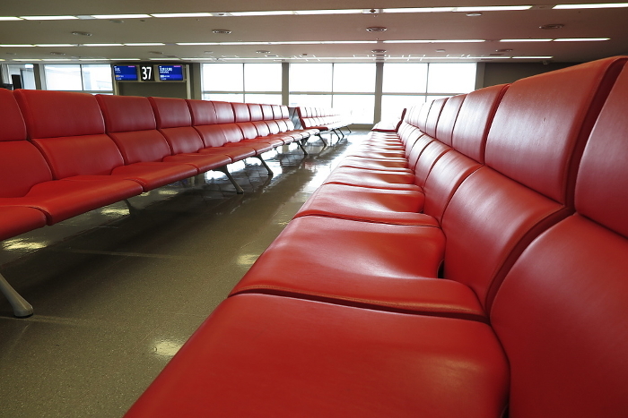 Departure lobby of an international airport with no people, rows of long seat-type benches (low angle, Kansai International Airport)
