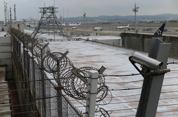 Fencing, barbed wire, and surveillance cameras on the roof of the airport terminal building (Taiwan Taoyuan International Airport)