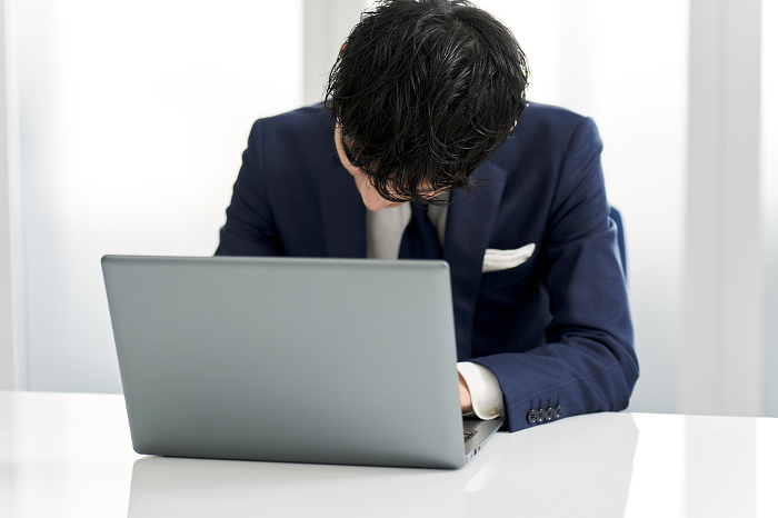 Japanese businessman nodding in front of computer (Male / People)