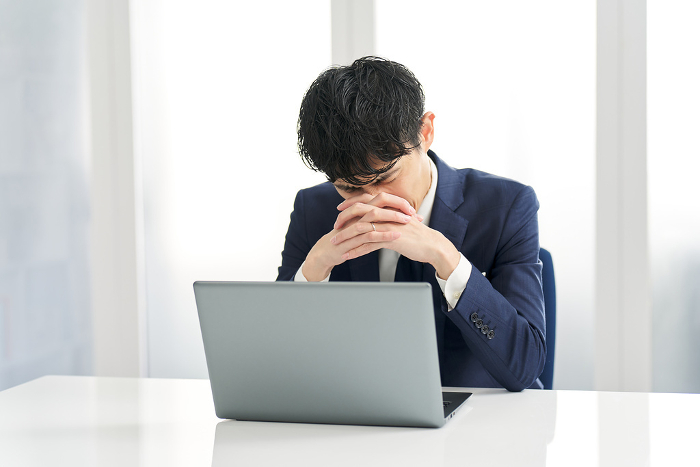 Japanese businessman struggling with his work decision （Male / People)
