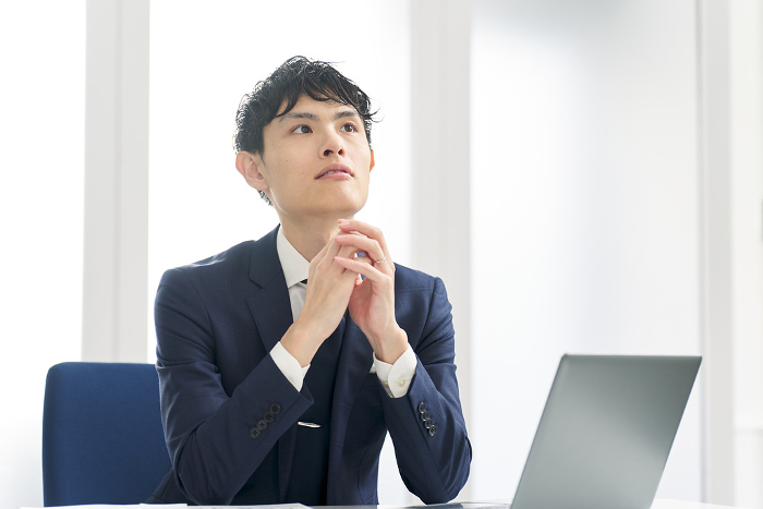 Japanese businessman pondering at work (People)
