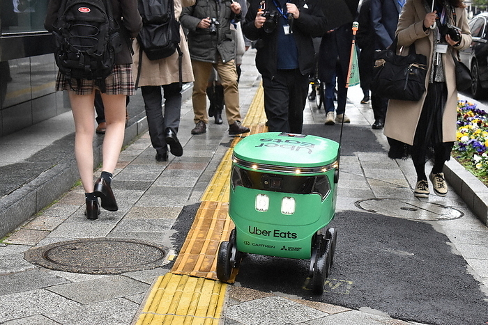 Uber Eats robot delivery Demonstration run in Tokyo A delivery robot traveling on a crowded sidewalk in Nihonbashi, Tokyo  photo by Yuko Shimada.
