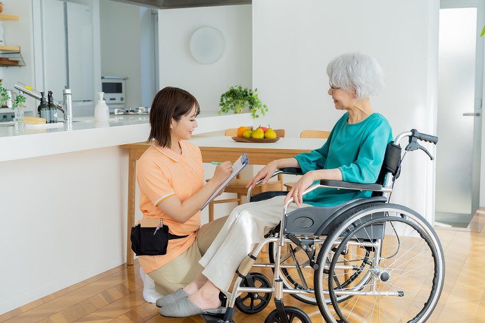A caregiver assists a Japanese woman in a wheelchair (People)