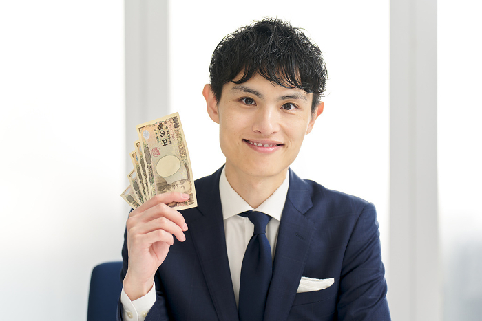 Japanese businessman paying money (Male / People)