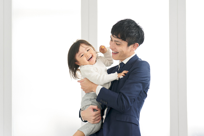 Japanese businessman holding his child before going to work (Male / People)