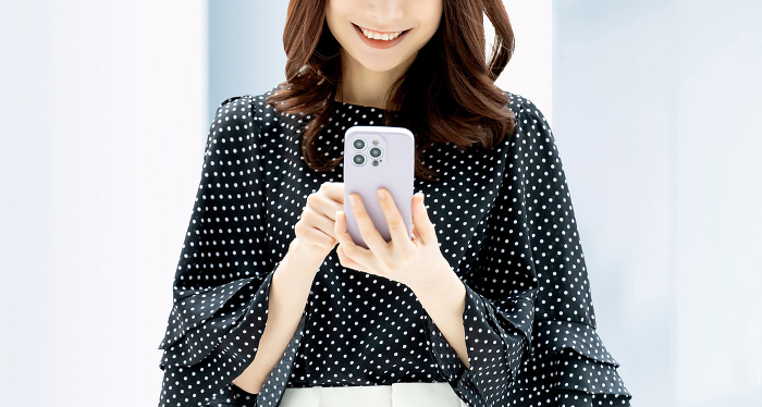 Japanese businesswoman operating a smartphone with a smile (Female / People)