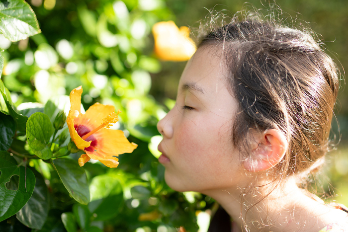 Girl smelling the scent of hibiscus