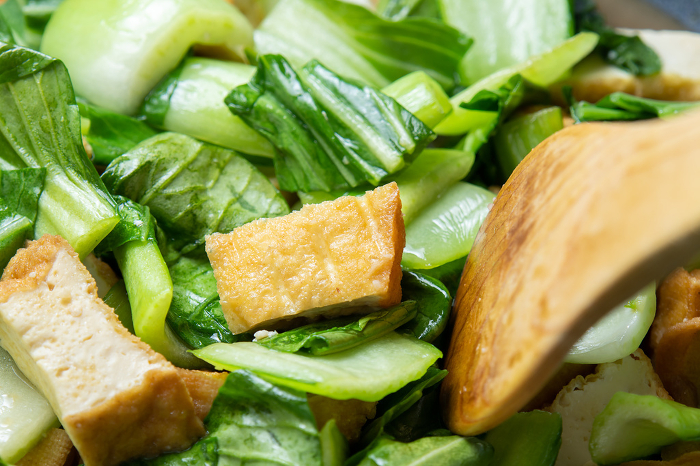 Stir-fried qinggengcai and thick fried tofu, cooking scene.