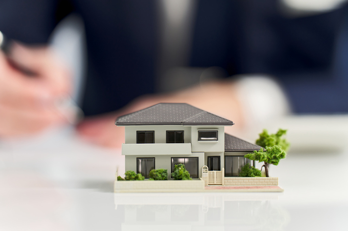 Miniature model of a house and a businessman