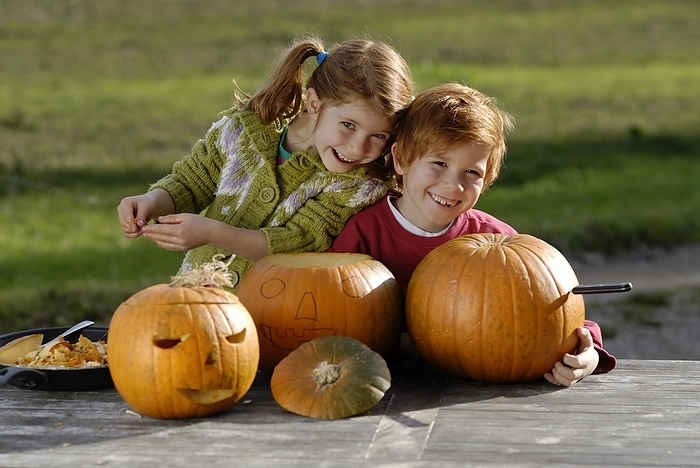 Halloween Two children carving pumpkins for Halloween decoration