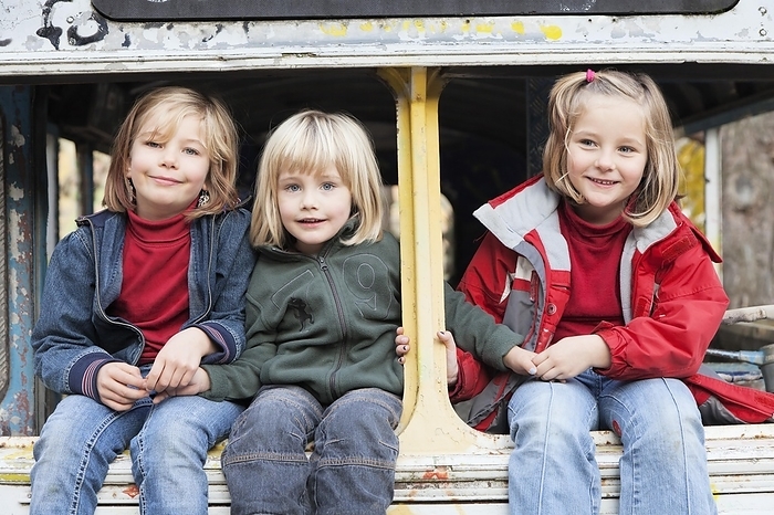 Smiling children Three children sitting in a disused bus, Esslingen, Baden W rttemberg, Germany, Europe