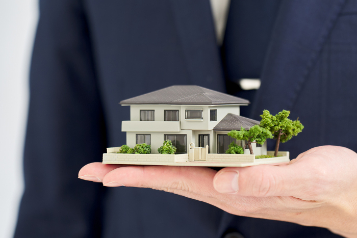 Businessman's hand with a model of a house