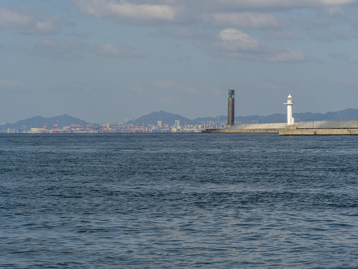 Lighthouse on the bank of Osaka Harbor and a view of Kobe Harbor