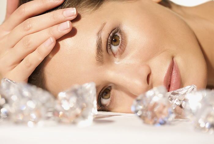 Close up of a young woman lying behind large diamonds