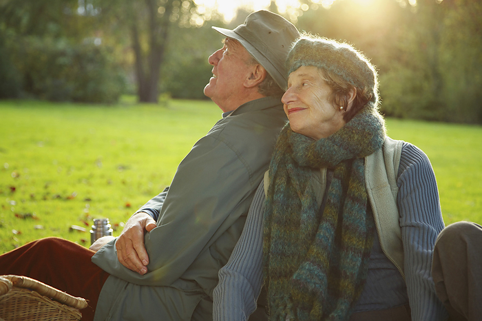 Senior couple sitting side by side in a park