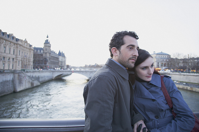 Young couple hugging on a bridge over the Seine river, Paris, France