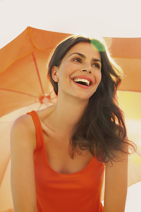 Smiling Woman Under Orange Parasol