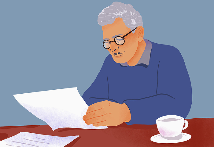 Senior man paying bills, reviewing paperwork at table