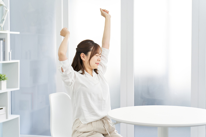Japanese woman stretching in her room (People)