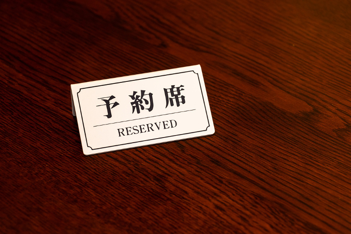 White tags indicating reserved seating on wooden table