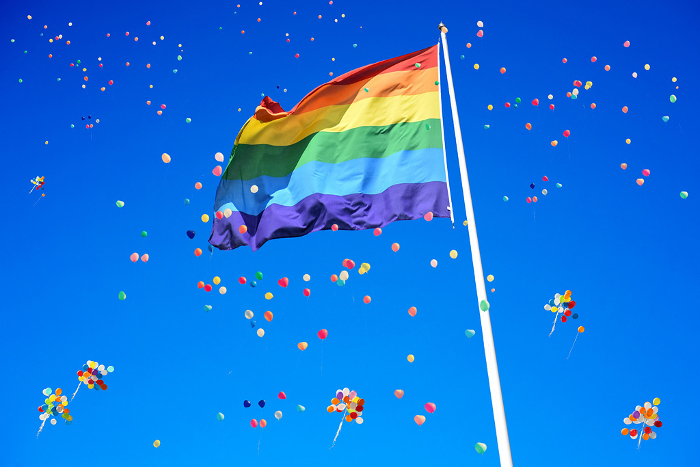 Balloons, blue sky and rainbow flags