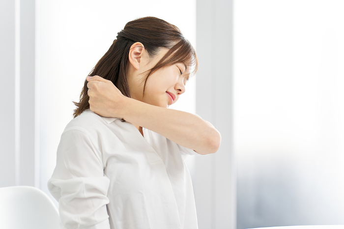 Japanese woman suffering from stiff shoulders.