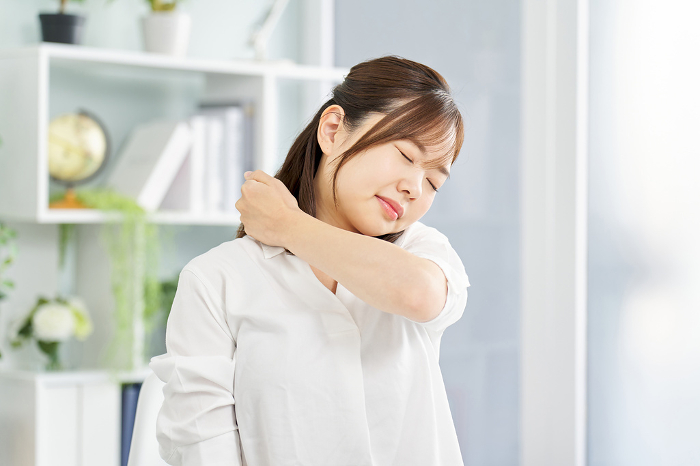 Japanese woman suffering from stiff shoulders.