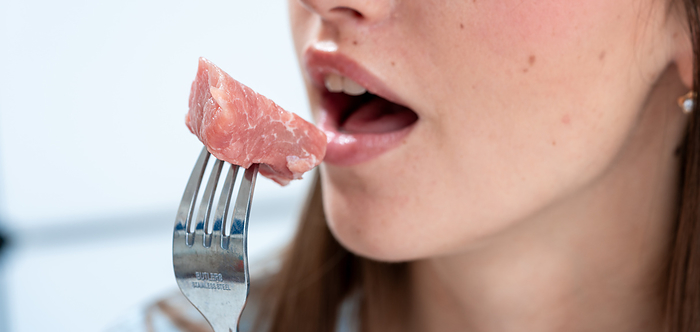 Woman eating red meat Woman eating red meat. This could represent the negative impact of red meat on health., by WLADIMIR BULGAR SCIENCE PHOTO LIBRARY