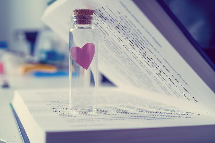 Glass vial with heart inside book Glass vial with heart inside book. This could represent a love potion., by WLADIMIR BULGAR SCIENCE PHOTO LIBRARY