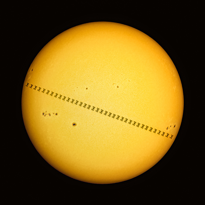 ISS movement across the Sun, composite image Composite image of the ISS  International Space Station  orbiting Earth silhouetted against the Sun. The images were taken over 0.73 seconds from Uhlirov, Czech Republic on the 3rd of June 2023. Dark sunspots, cooler areas of the Sun s surface caused by magnetic flux, are also visible., by PETR HORALEK SCIENCE PHOTO LIBRARY