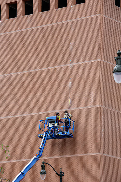 Workers marking wall of parking garage Workers measuring and marking the wall of Bricktown parking garage in preparation for hanging a display in Detroit, Michigan, USA., by JIM WEST SCIENCE PHOTO LIBRARY