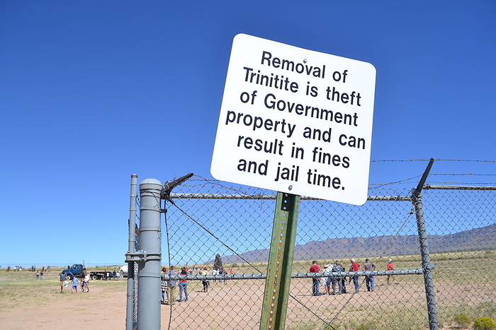 Sign warning visitors not to remove trinitite, Trinity Site, USA Sign warning visitors not to remove trinitite from Trinity Site, New Mexico, USA. This was the site of the Trinity Test, the first ever nuclear explosion, on the 16th of July 1945, as part of the Manhattan Project. This explosion created trinitite, an altered silicate resembling rough green glass. The extreme temperatures of the nuclear explosion melted the native sandstone soil. As the material cooled it formed a glassy structure. The greenish colour comes from iron in the sand. Twice a year Trinity Site opens to the public, and though trinitite can still be found there, its removal is prohibited by the US army., by US DEPARTMENT OF DEFENSE, Wendy Brown SCIENCE PHOTO LIBRARY