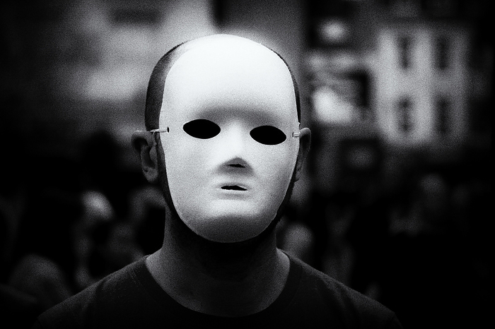 Anonymous person wearing white mask Anonymous person wearing a white mask in a city street., by JEREMY WALKER SCIENCE PHOTO LIBRARY
