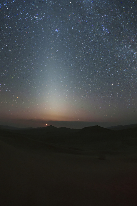 Zodiacal light over the sand dunes, Lut Desert, Iran The cone shaped zodiacal light glows in the dark sky of Lut Desert, Iran. The crescent Moon can be seen just above the horizon., by AMIRREZA KAMKAR   SCIENCE PHOTO LIBRARY