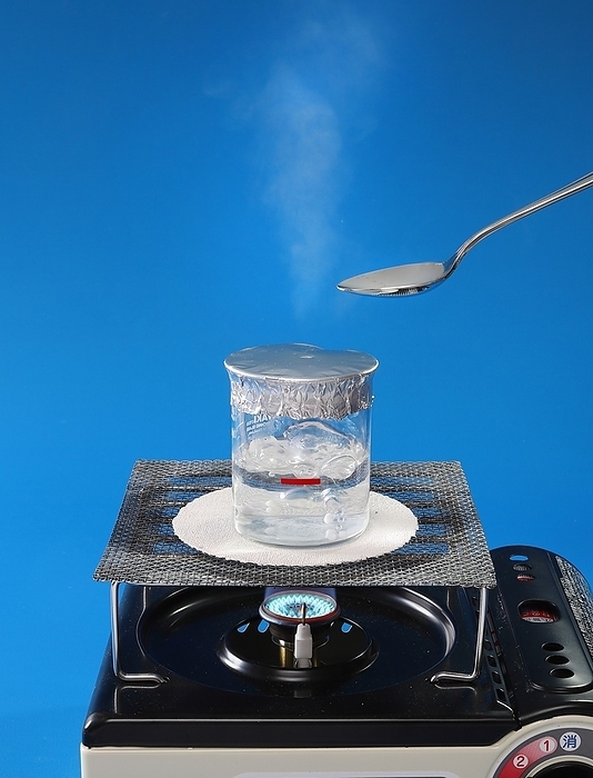 A beaker with an aluminum lid is heated with a hole in it, and a metal spoon is placed near the steam. A beaker with an aluminum lid is heated with a hole in it, and a metal spoon is placed near the steam.