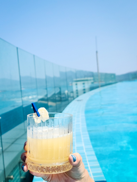 Holding cocktail at swimming pool background